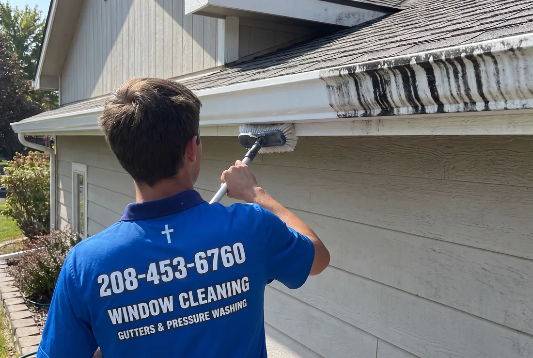 Reflekt crew scrubbing black tiger stripes off gutter faces in the Treasure Valley