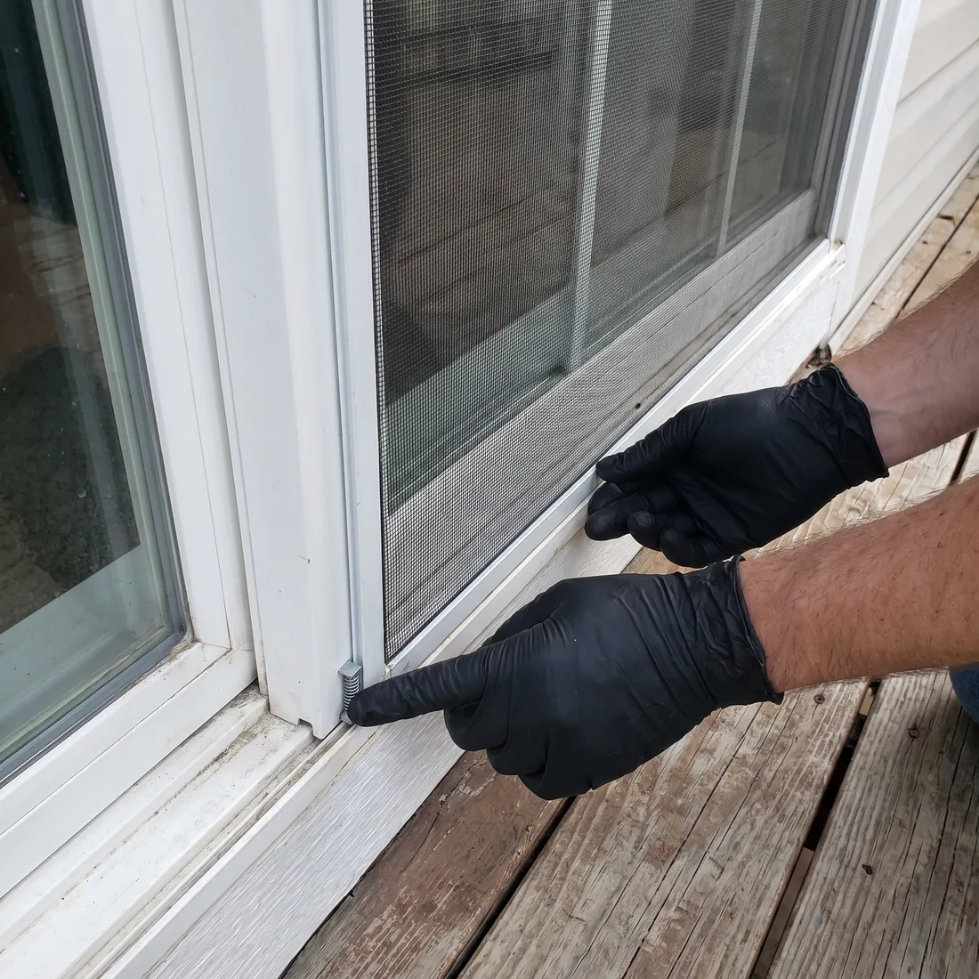 Reflekt crew refitting a freshly washed window screen into its original window